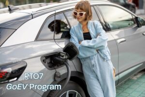 Lady standing next to electric car while charging.
